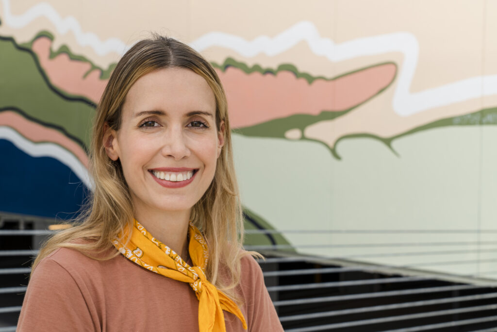 Artist Soledad Fernandez-Whitechurch posing with her mural, Virtual Hike, at the Bouldin Creek Commons garage in Austin